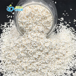 White crystalline Potassium Sorbate granules pouring from a glass bottle