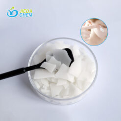 The White Flake Cetearyl Glucoside/Sorbitan Olivate on the black spoon