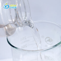 The transparent liquid Cetyl Ethylhexanoate contained in the small bottle is being poured into the beaker